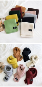 Close-up of thick knitted winter scarves in multiple colors with woven label detail