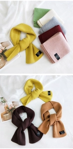 Close-up of ribbed knit texture on colorful winter scarves with stylish brand labels