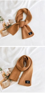 Detail showing the fine knit texture and black label on a caramel winter scarf