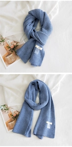 Gros plan sur l'écharpe en maille bleu brume avec étiquette tissée et texture douce