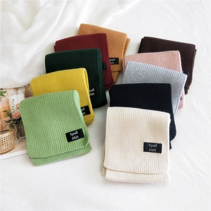 Double-sided knit scarves in ten colors with brand labels on a white cloth