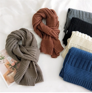 Detail of multi-color thick knit scarves showing ribbed texture and soft wool material