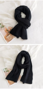 Detail of black chunky knit scarf showing thick ribbed edge and warm winter texture