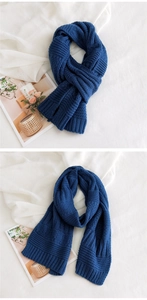 Close-up detail of dark blue chunky knit scarf texture with warm thick woolen yarn