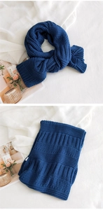 Detail view of thick navy blue knitted scarf showing ribbed texture and warm fabric