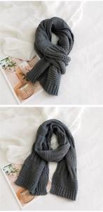 Detail of dark grey thick knit scarf showing the chunky ribbed texture and warm fabric