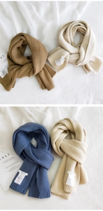 Close-up of thick knit scarves in camel, beige, and blue with woven brand labels
