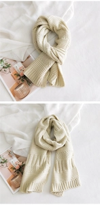 Detailed close-up of cream chunky knit scarf texture with ribbed edges for winter warmth