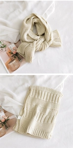 Detail of chunky knit cream scarf showing honeycomb texture and care label specifics