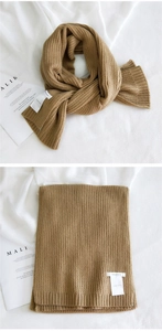 Macro shot of camel ribbed knit scarf with texture details and white fabric brand label
