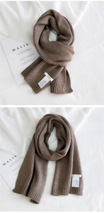 Macro detail of dark coffee knitted scarf showing rib texture and white brand label