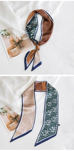 Détail d'un foulard long en soie avec des motifs floraux en vert et marron