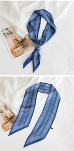 Gros plan d'un foulard en soie bleu foncé avec motif géométrique à chevrons blancs