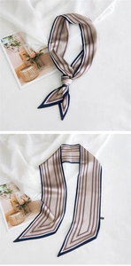Vue détaillée du foulard en soie rayé avec bords bleu marine et extrémités pointues sur tissu