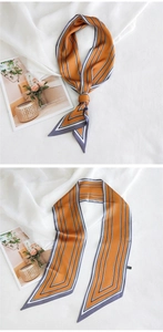Détail d'un foulard étroit effet soie à rayures géométriques orange et bleu marine