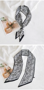 Gros plan d'un foulard en soie à motif zébré sur un magazine de mode avec un éclairage doux
