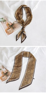 Détail d'un foulard en soie à imprimé léopard avec tons marron et bords biseautés