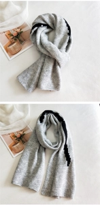 Detailed close-up of thick grey knit scarf featuring black zigzag stripe patterns
