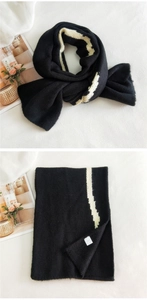 Detailed texture of thick black and white striped knitted scarf with soft woven fabric