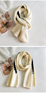 Detailed knit texture of a cream scarf with black zigzag patterns for winter