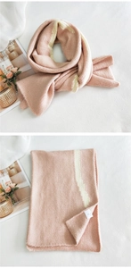 Detail of pink and beige striped knitted scarf with soft cashmere-like texture