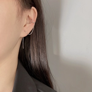 Detail of silver long tassel ear bone clip with chain earrings worn by a model