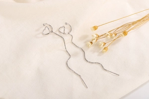 Detail of silver long tassel ear cuffs with hollow heart design and fine box chains