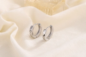 Macro shot of S925 sterling silver sun and moon hoops with material hallmarks
