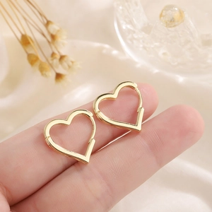 Boucles d'oreilles créoles dorées en forme de cœur présentées pour taille réelle