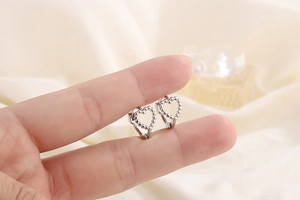 Vue détaillée des boucles d'oreilles cœur en argent S925 avec texture perlée fine