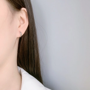 Minimalist silver sun and moon hoop earrings shown on a model for a stylish daily look