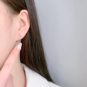 Élégantes boucles d'oreilles cœur en argent S925 avec bord perlé délicat portées par un mannequin