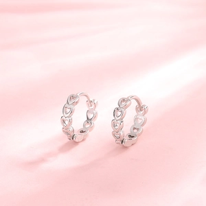 Minimalist S925 sterling silver hollow heart hoop earrings on pink background