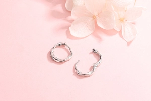 Détail de créoles minimalistes en argent sterling S925 avec un design fluide torsadé