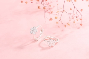Close-up of S925 silver flower hoop earrings with white petals on pink background