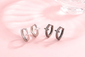 Macro view of S925 sterling silver hoop earrings with embossed cross star patterns