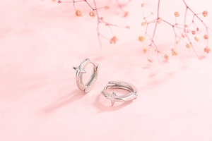 Close-up of S925 sterling silver hoop earrings with engraved cross star patterns