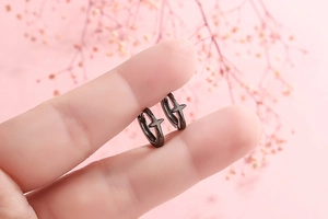 Close-up of black S925 sterling silver hoop earrings with 3D cross charm design