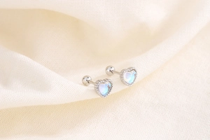 Macro shot of S925 sterling silver heart-shaped moonstone screw-back stud earrings