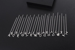 Detailed collection of 26 silver alphabet letter threader earrings on a black display