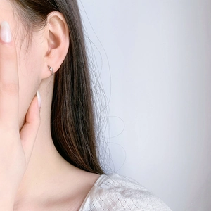 Minimalist S925 sterling silver star hoop earrings worn by a model in a modern style