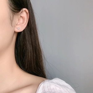 Close-up of a sterling silver butterfly screw-back earring with sparkling zircon stones