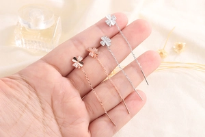 Detailed view of lucky four-leaf clover tassel earrings with cubic zirconia inlay