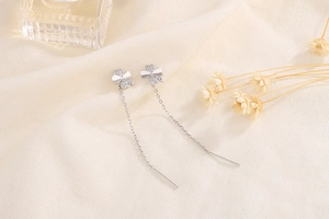Close-up of silver four-leaf clover ear threader with sparkling pavé cubic zirconia