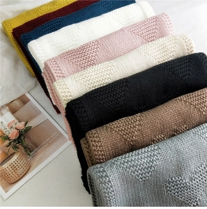 Macro detail showing thick knit texture with embossed heart patterns in multiple colors