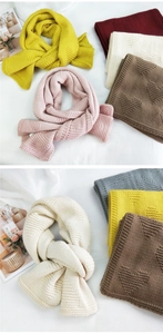 Close-up of thick knit scarf showing textured heart patterns and soft wool texture