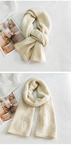 Close-up of cream knit scarf featuring textured 3D heart patterns and thick warm wool fabric