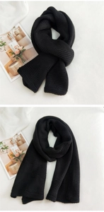 Close-up of thick chunky knit black scarf texture showing high-density waffle pattern