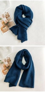 Detail of navy blue thick knit scarf showing the warm wool texture and woven patterns