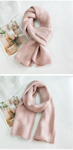 Close-up of pink knit scarf showing thick yarn texture and woven heart patterns